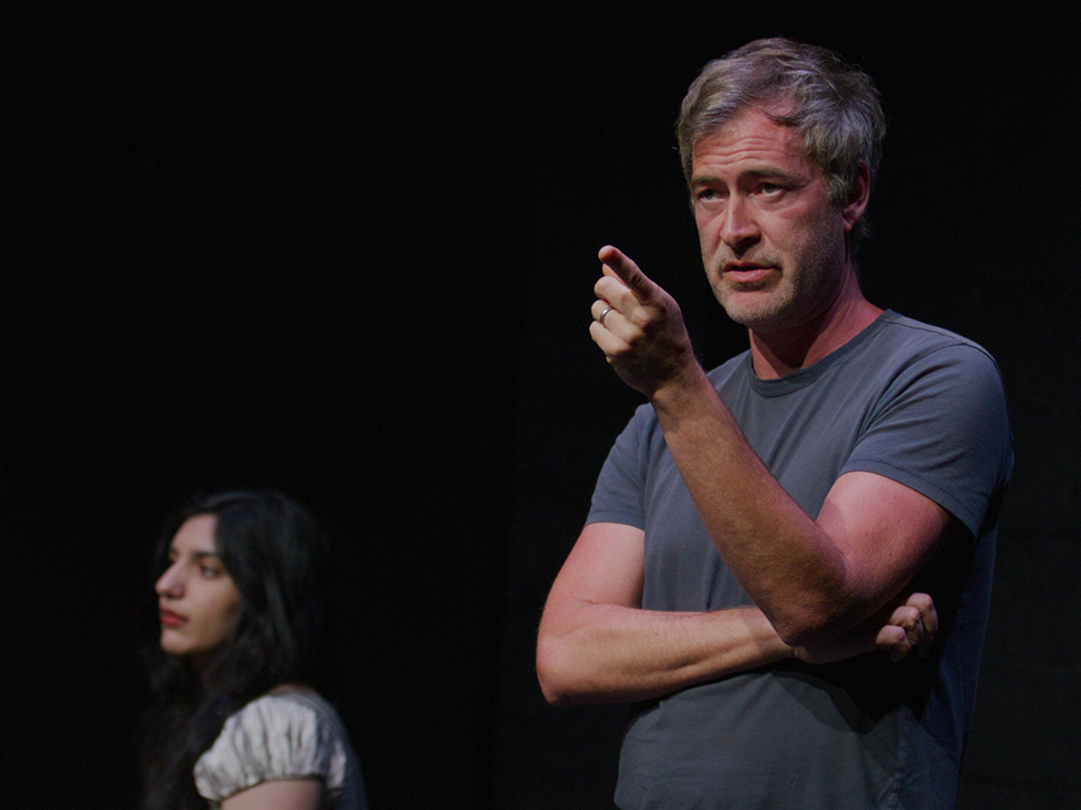 Mark Duplass lecturing in a dark theatre
