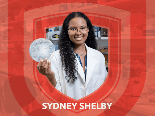 Sydney Shelby holds a Petri dish in a biology lab.