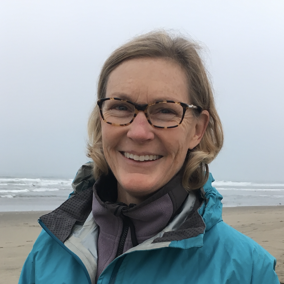 A smiling person on a foggy beach.