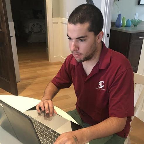 A person working on a laptop at a table.