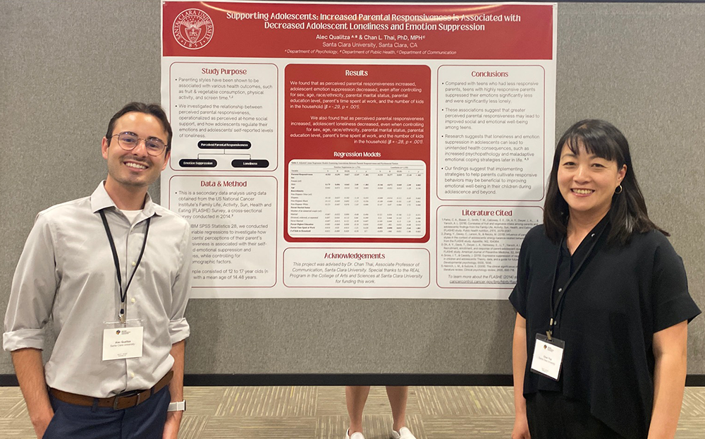 Alex Qualitza and Chan Thai standing next to their poster 