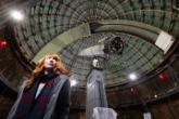 Kimberly Dill inside the main dome at Lick Obervatory next to the telescope