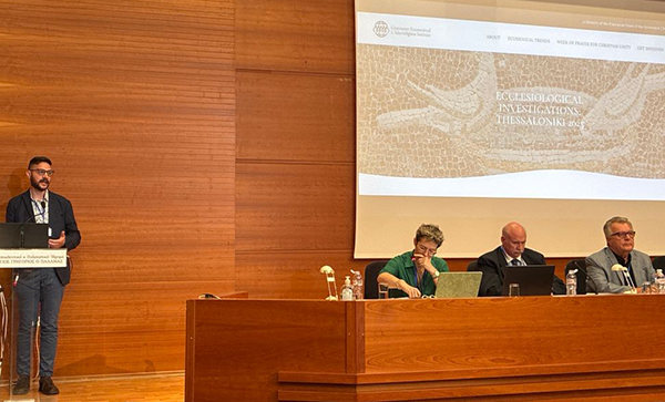 Eugene Schlesinger at podium on large stage with visual slides