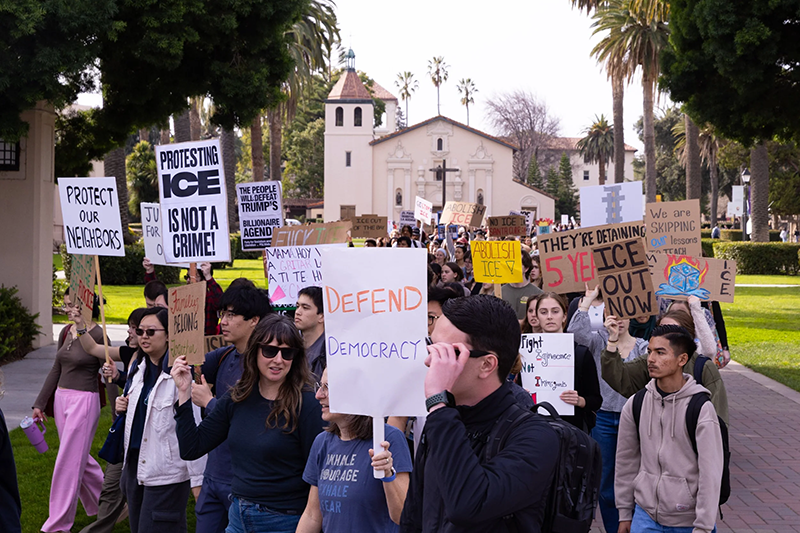Students march on campus with the Mission Church in the background