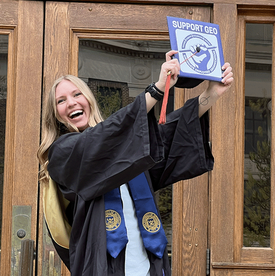 Skyler Kriese in her graduation gown holding her cap.