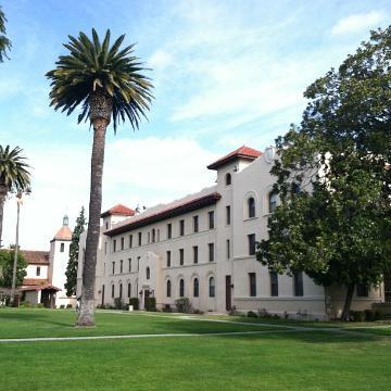Old building with tall palm trees on a sunny day. 
