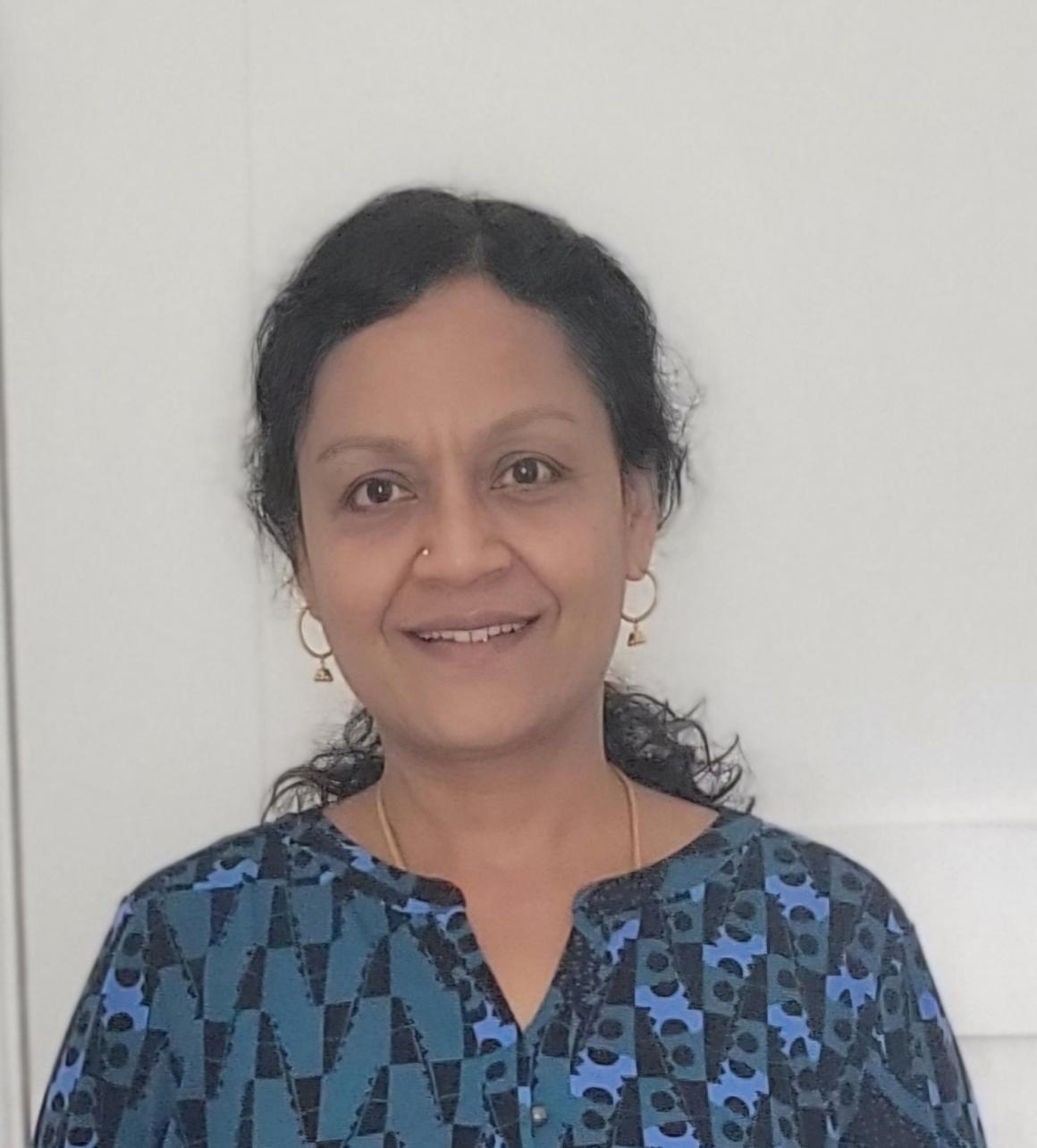headshot of woman with dark hair and a blue blouse