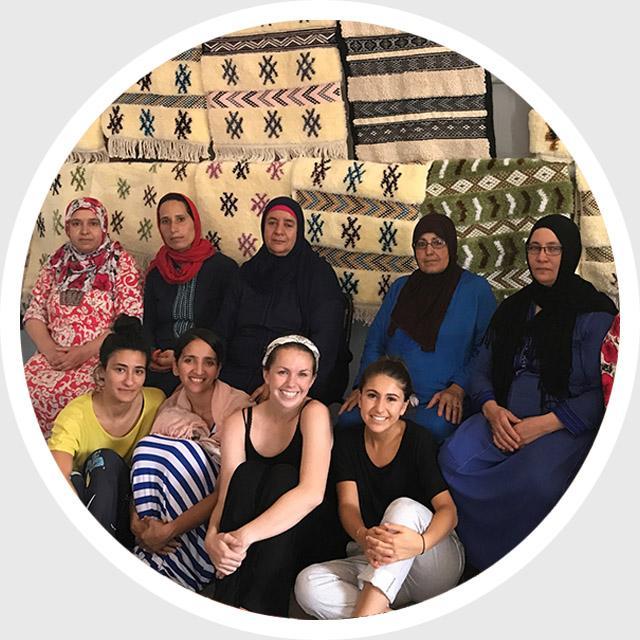 Group of people posing together with a scenic building in the background.