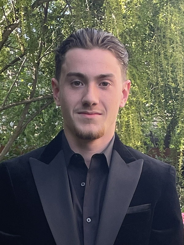 Leonard Cappa headshot outdoors with green trees in background