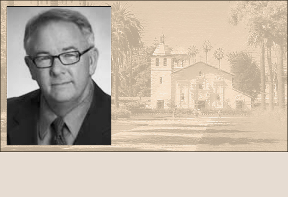 A man in glasses, with a background of a historic building.