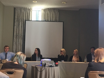 A panel discussion with six people seated at a table.