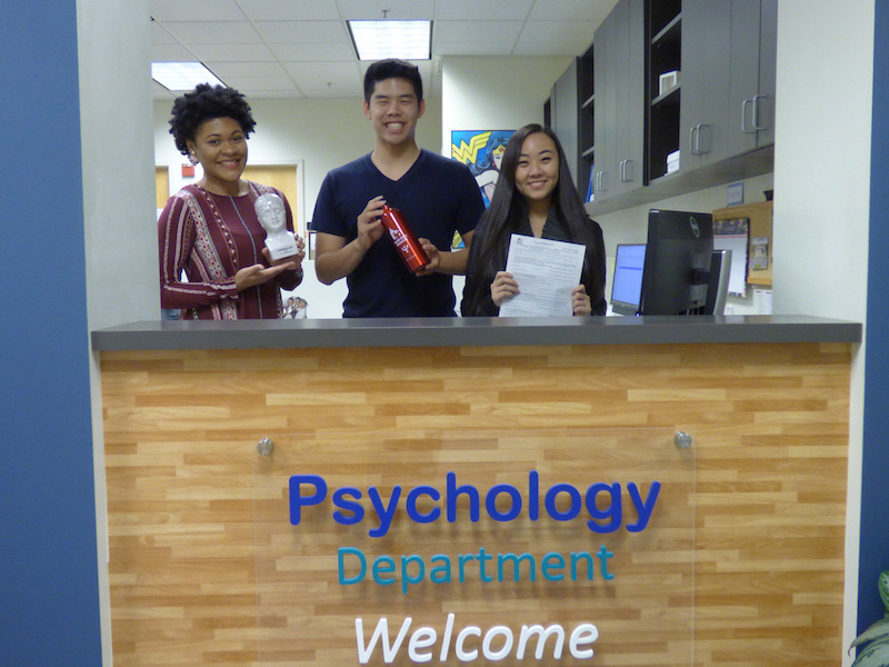 Three people behind front desk with 'Washington Animal Clinic' sign.