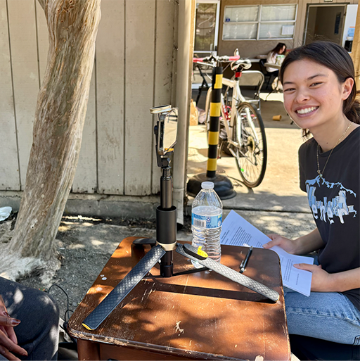 Public Health Capstone student Elsa Kinney conducts a video interview with a guest at Mobile Showers (photo permission granted by interviewee). 