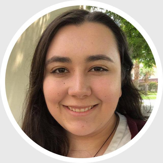 Person smiling with a blurred background of trees and building, circular frame.