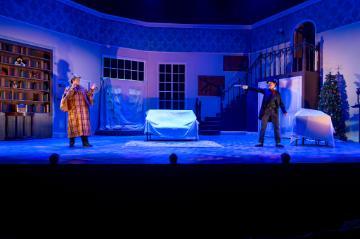 A villain in black pointing a pistol at Sherlock Holmes