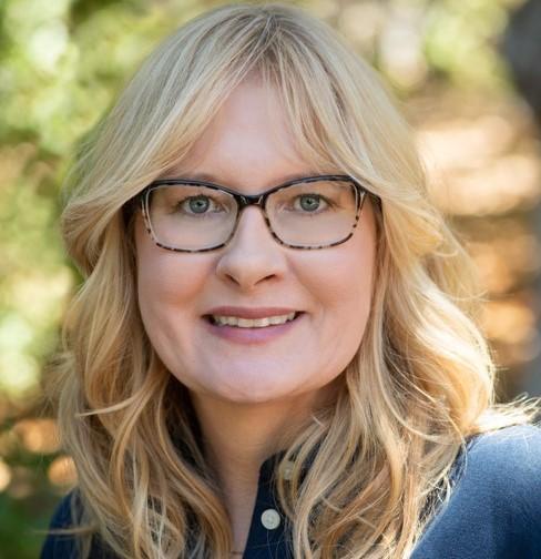 A woman with glasses smiling