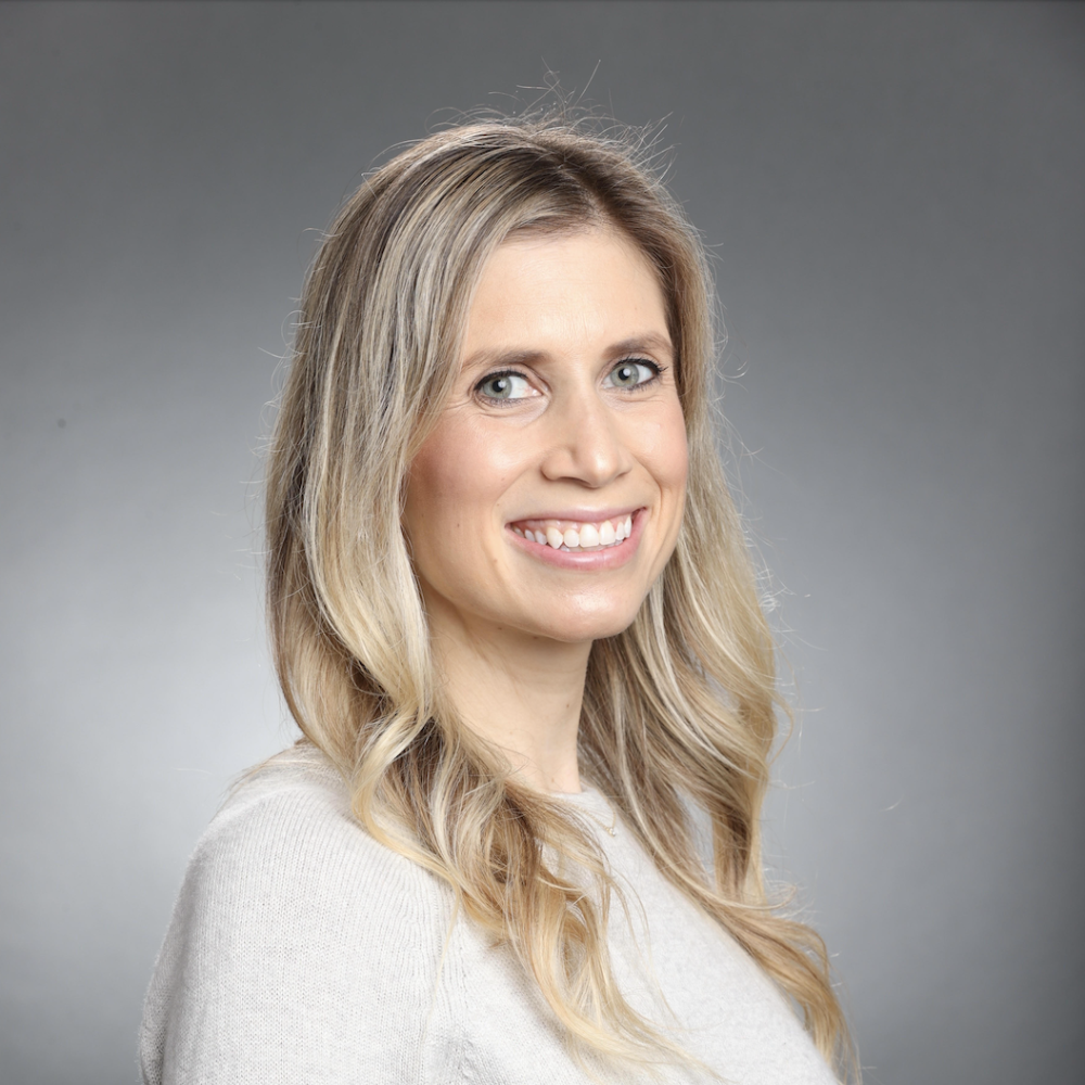 Smiling person with grey background. Image labeled 