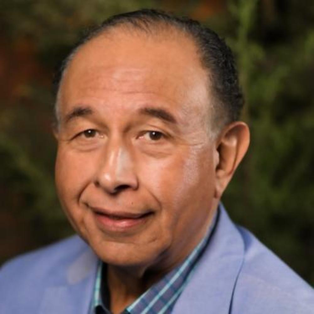 A man in a blue suit jacket and checkered shirt.