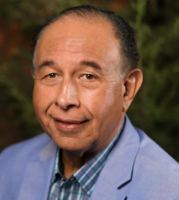 A man in a blue suit jacket and checkered shirt.