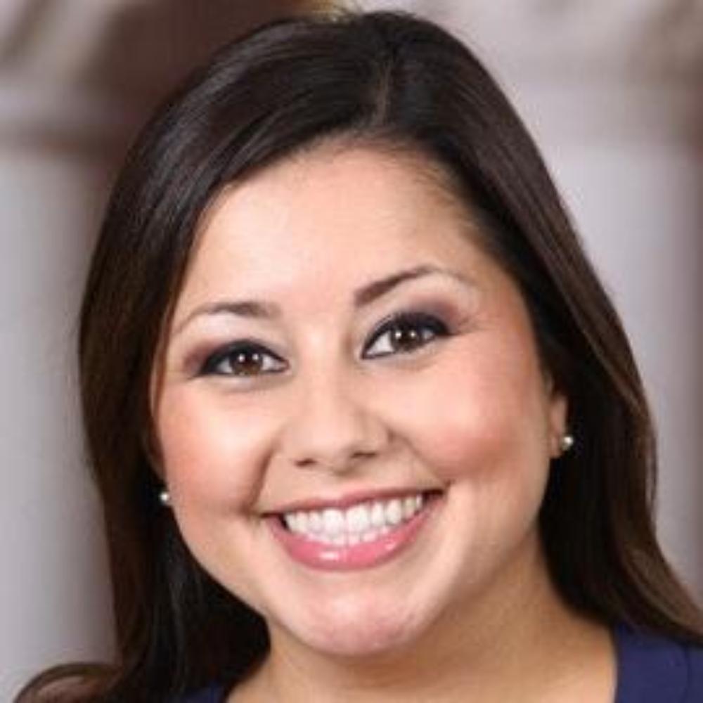 A woman smiling in a dark blue top.