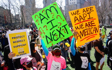 Crowd holding brightly colored protest signs in Atlanta.