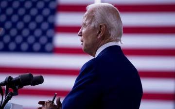 President Joe Biden stands at podium in front of a U.S. flag.
