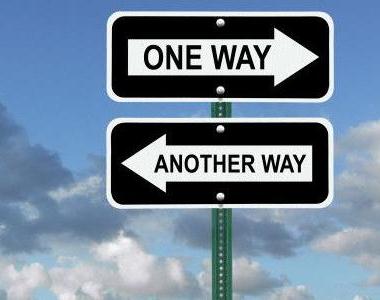 Two arrow road signs. One points right and has text reading, 