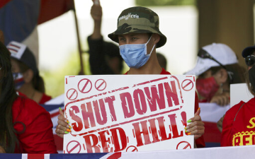 A man holds a sign reading 