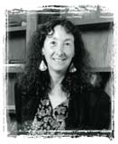 A woman smiling in front of a bookshelf.