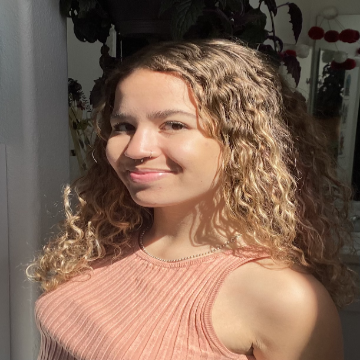 A person smiling in a sleeveless top.