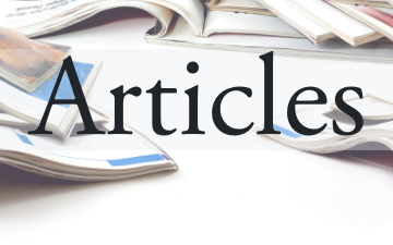 Magazines and newspapers stacked and scattered on a table. 