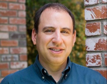 Eric Goldman standing in front of brick wall