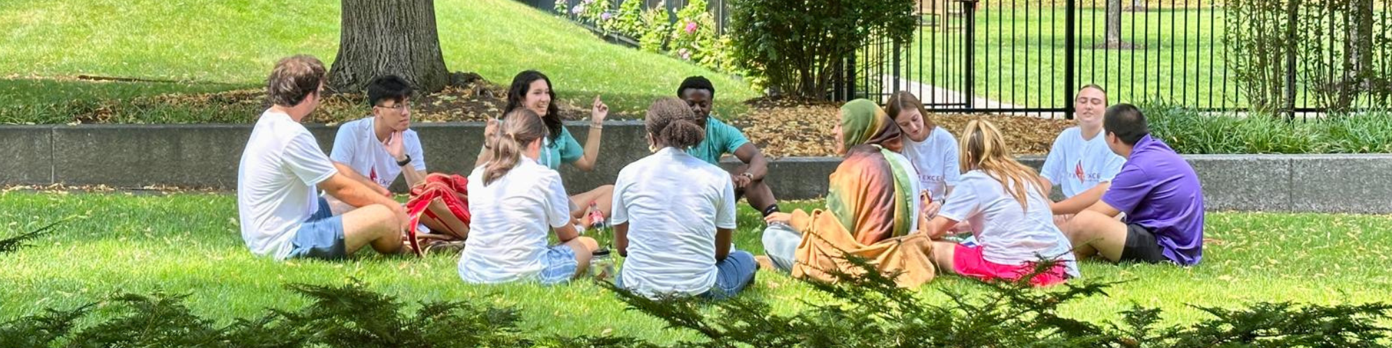 AMDG 2025 students sitting in circle on grass