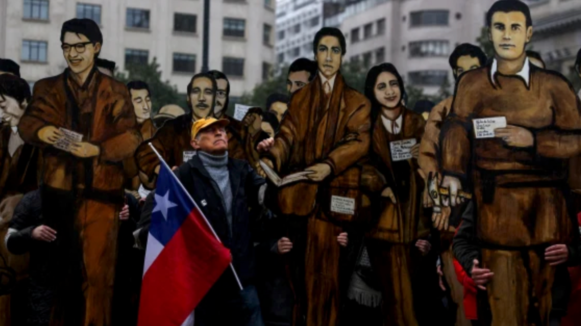 Chile Man with Flag in front of a mural 