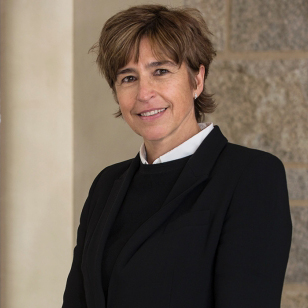 A woman in a black suit smiling. image link to story