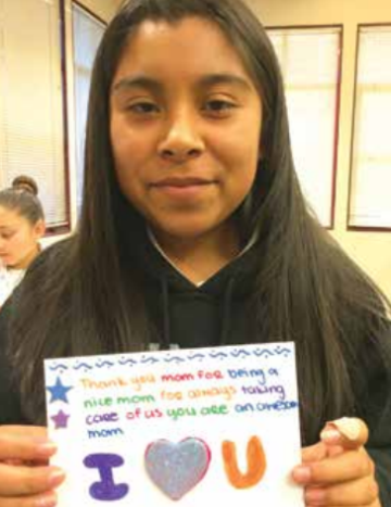 A person holding a colorful, handwritten note with 