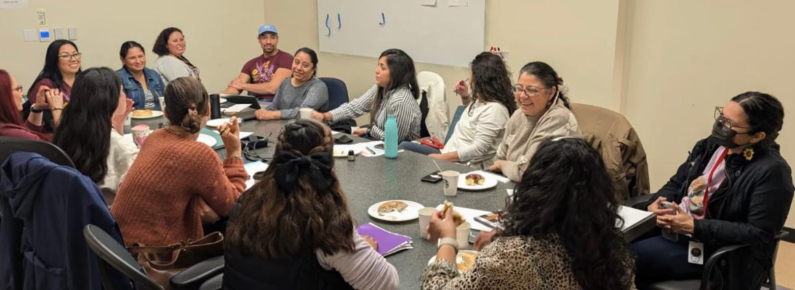 Caminos Al Bienestar Meeting community members sitting at conference table