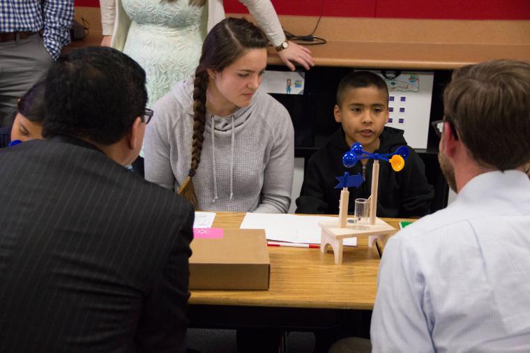 People sitting around a table having a discussion with papers and books in front of them.