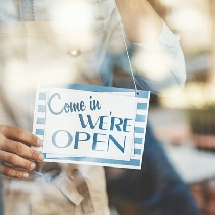 Store owner flipping come in we're open sign