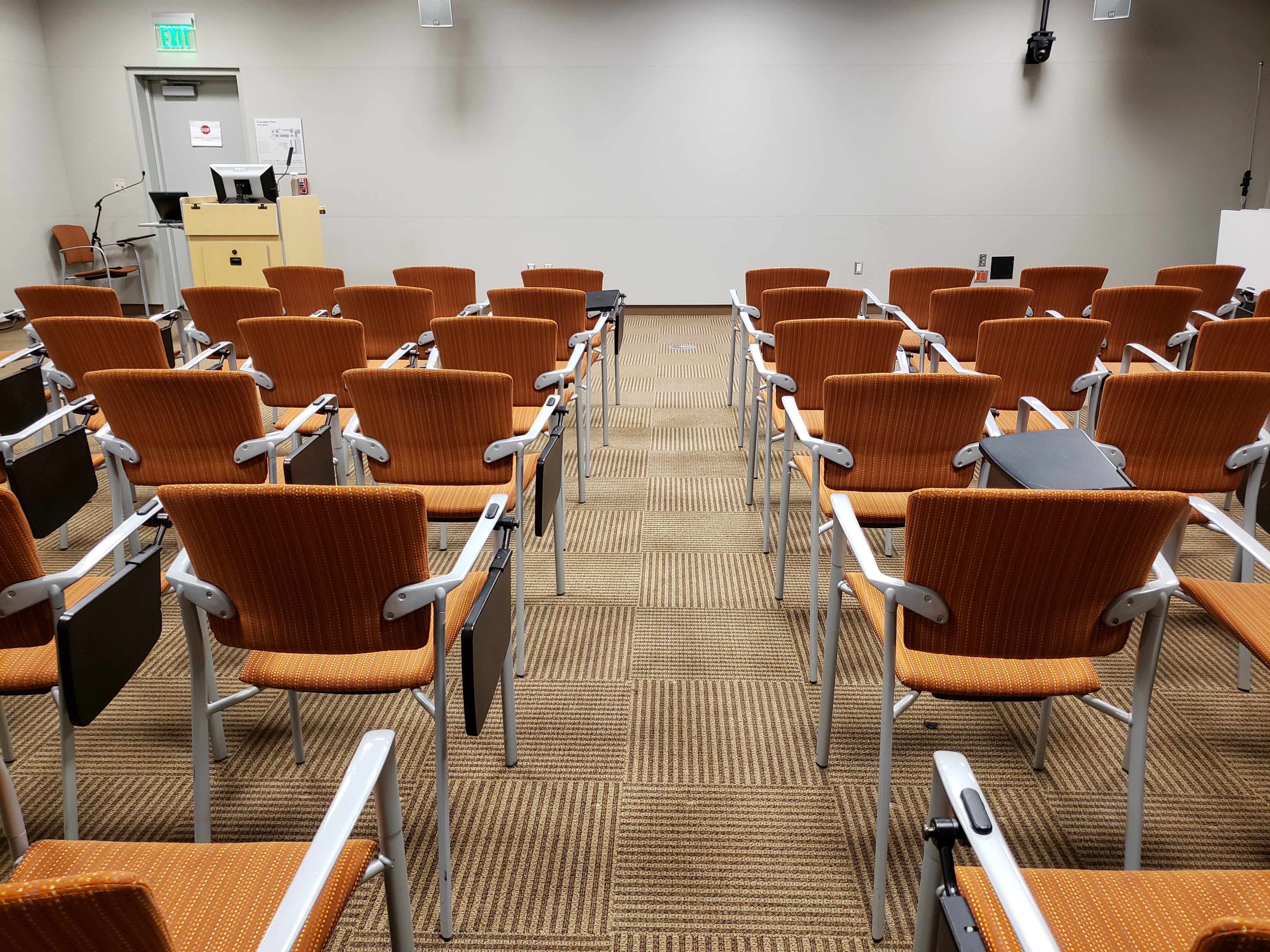 Rows of red chairs in an empty lecture hall.