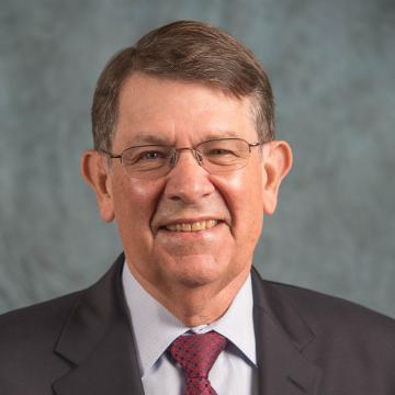 A man in a suit and tie smiling.