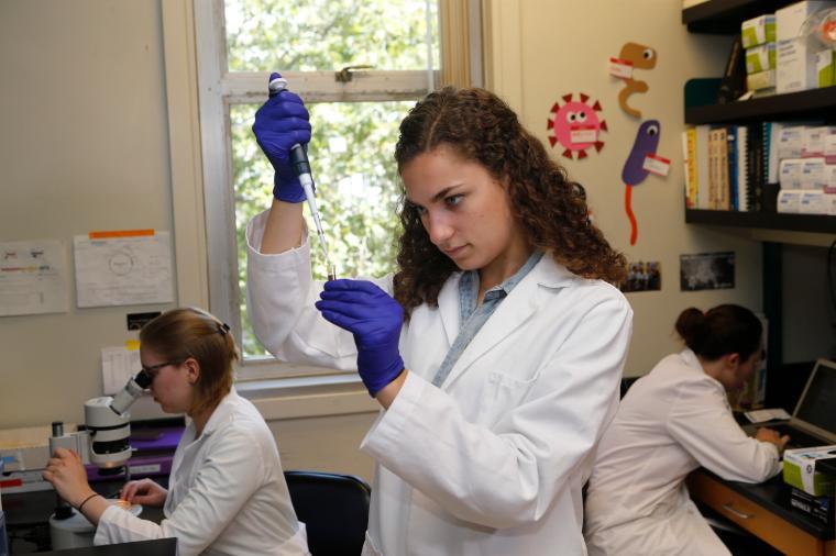 Two laboratory researchers work with instruments and computers.