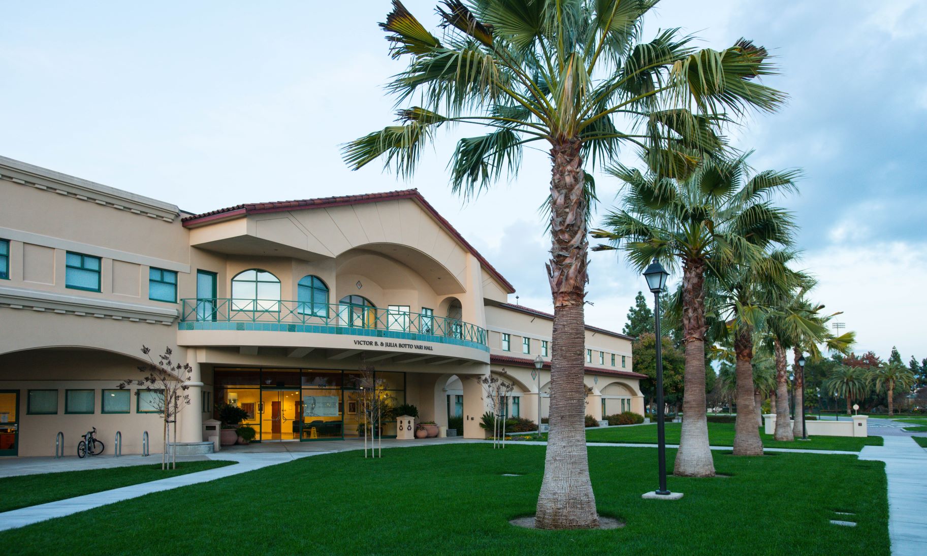 Modern building at SCU with palm trees on lawn.