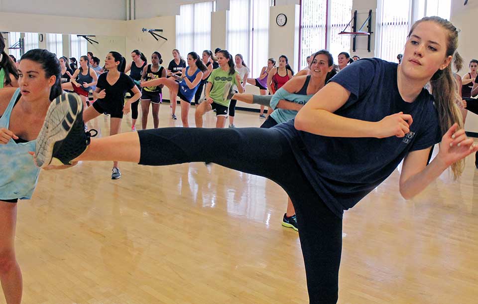 Two people practicing kicks in a fitness class.