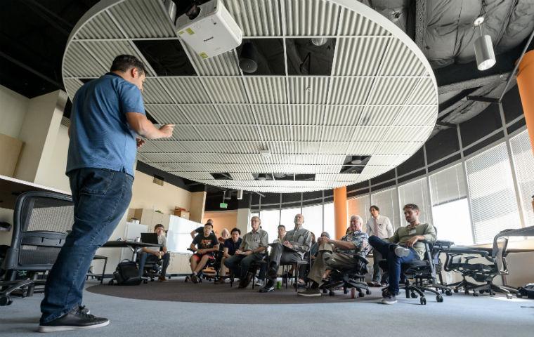 A student pictured presenting to small seated group for Bronco Venture Accelerator