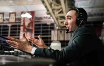 Jack Benjamin announces basketball game from scorer's table