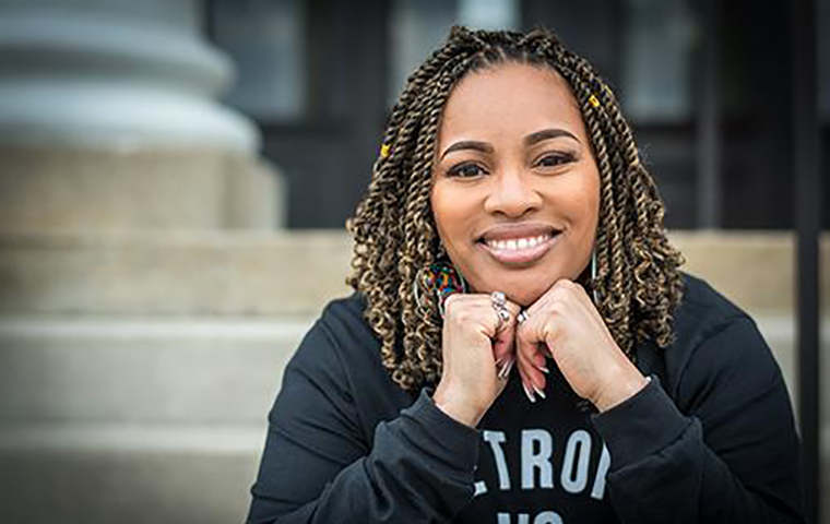 Kai Harris sitting on stairs with her hands underneath her chin