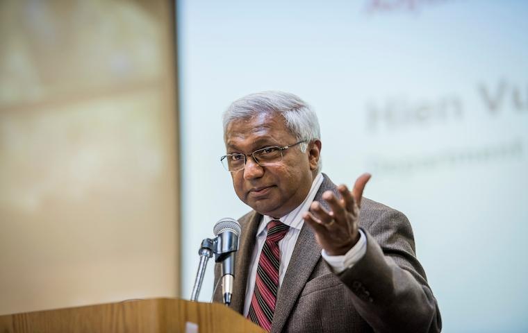 An individual speaking at a podium with a microphone. image link to story