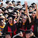 three SCU graduating women cheering in cap & gown 2018