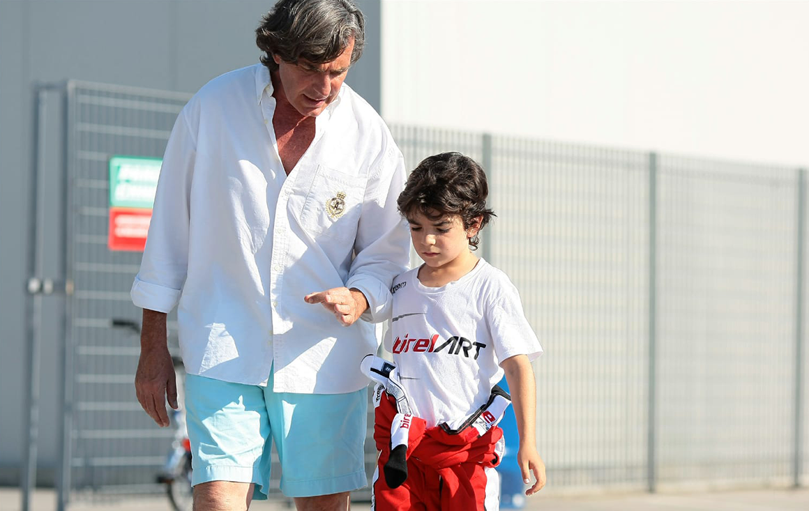 A father talks to his son, a racer, on a track.